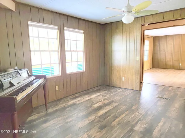 a view of an empty room with window and bathroom