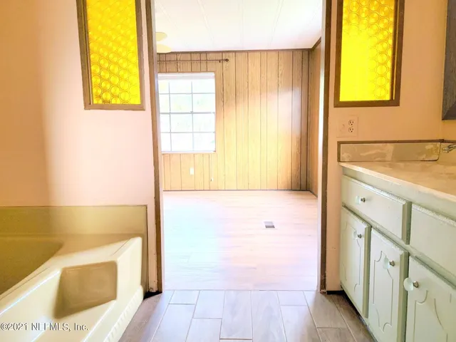a bathroom with a tub sink and a mirror