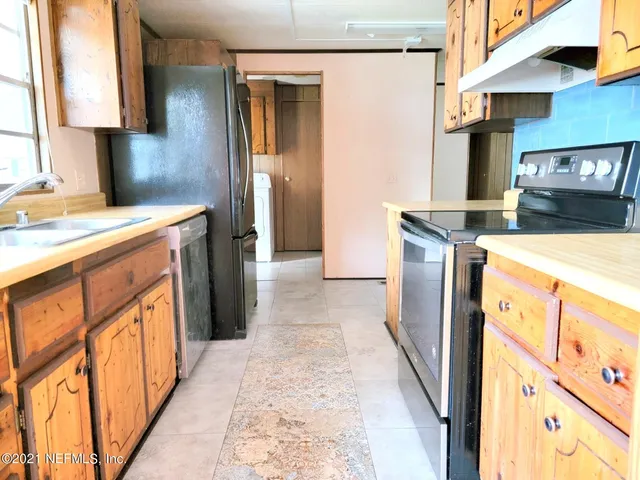 a kitchen with a sink stove and a refrigerator