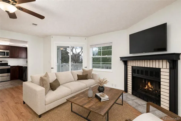 a living room with furniture a flat screen tv and a fireplace