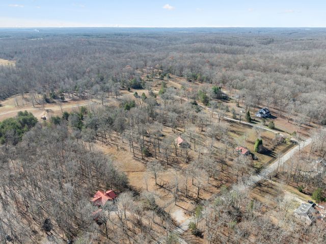 a view of a dry yard with wooden fence
