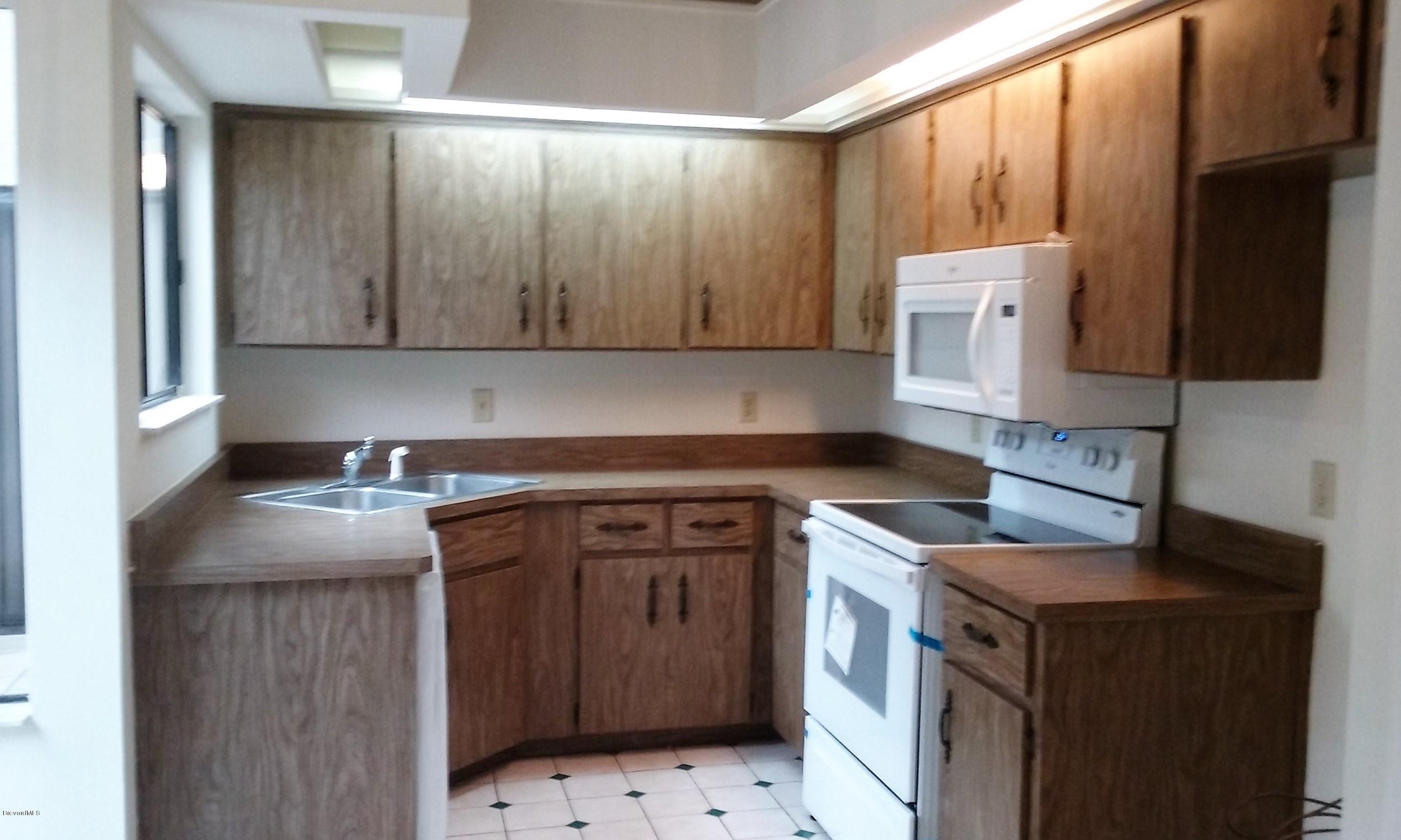 366 Myrtlewood Road Melbourne, FL 32940 - Photo 28 of 43 a kitchen with a sink stove and cabinets