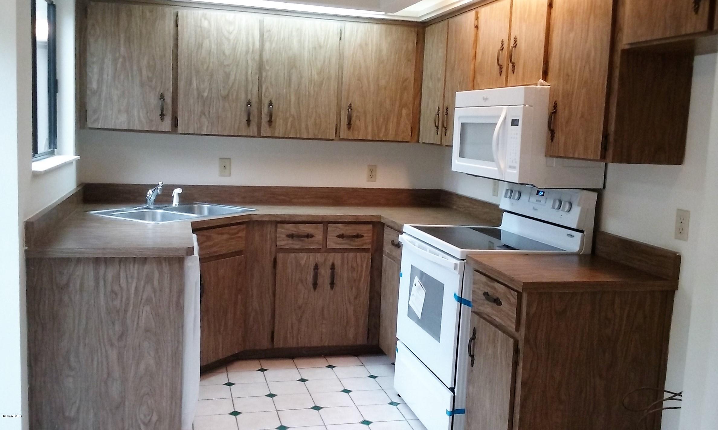 366 Myrtlewood Road Melbourne, FL 32940 - Photo 29 of 43 a kitchen with granite countertop a sink stove and cabinets