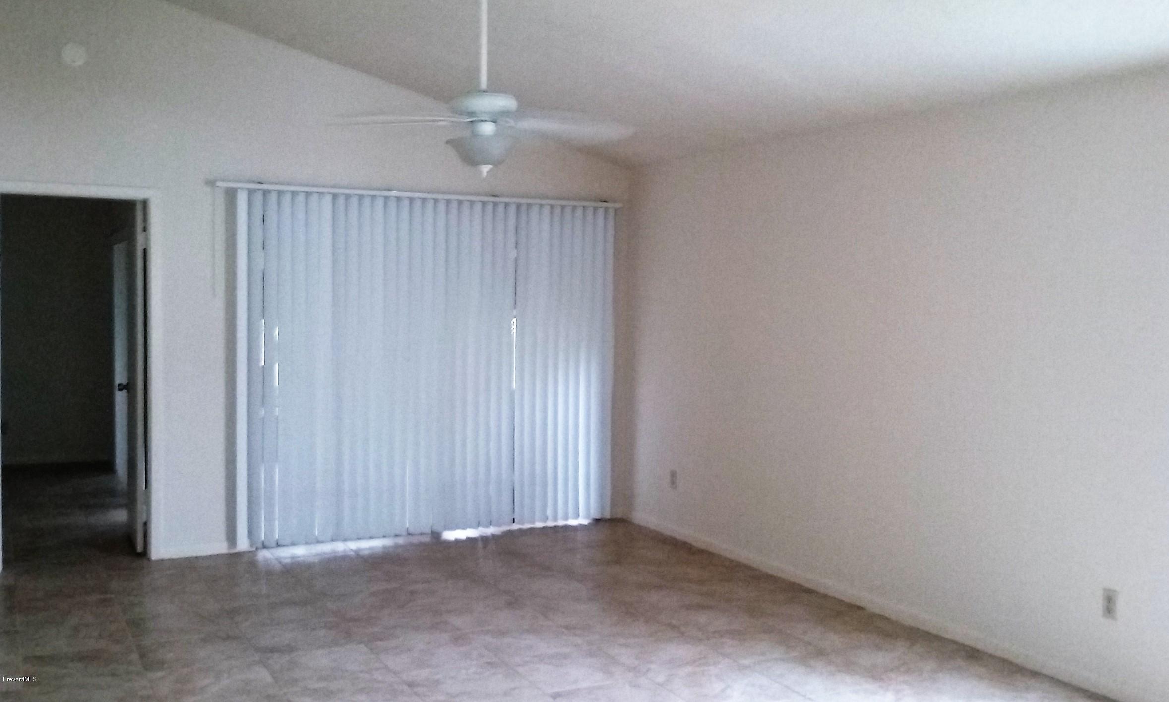 366 Myrtlewood Road Melbourne, FL 32940 - Photo 39 of 43 an empty room with a chandelier fan and closet area