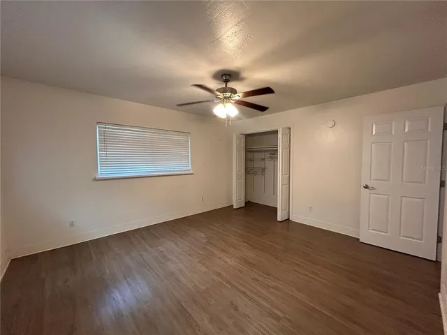 a view of an empty room with wooden floor