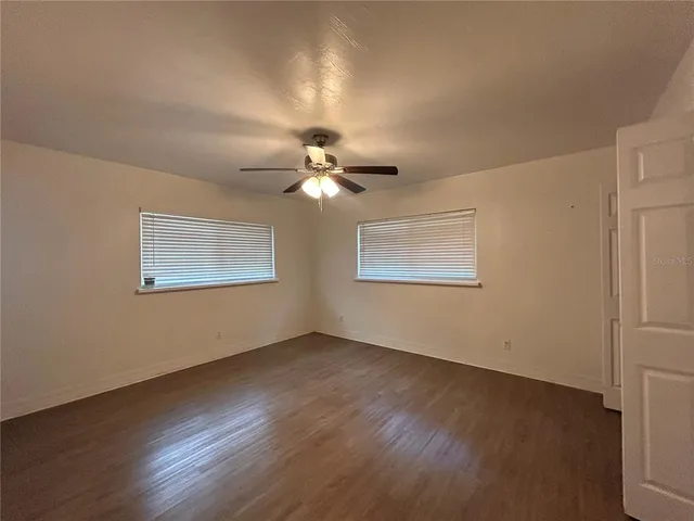 a view of an empty room with wooden floor