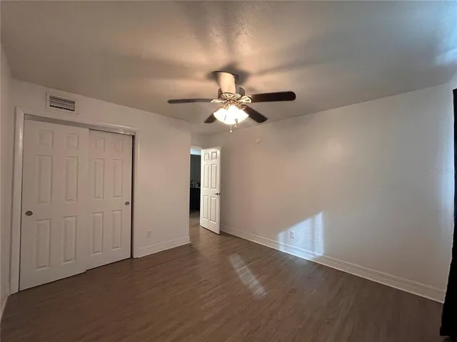 a view of an empty room with wooden floor