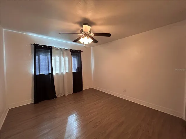 a view of an empty room with wooden floor