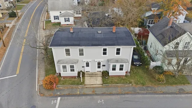 an aerial view of residential houses with outdoor space and parking