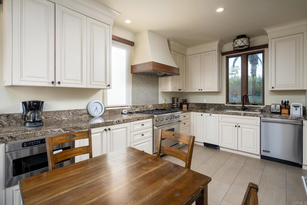7029 Las Colinas Rancho Santa Fe, CA 92067 - Photo 4 of 10 a kitchen with granite countertop white cabinets and white appliances