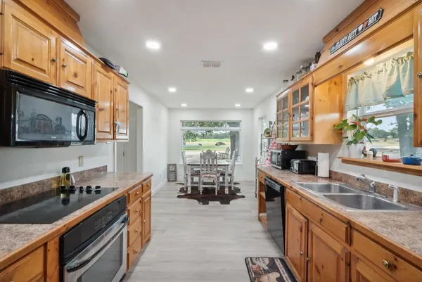 a kitchen with stainless steel appliances granite countertop sink stove top oven and cabinets