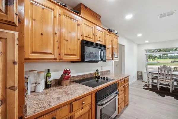 a kitchen with stainless steel appliances granite countertop a sink a stove and cabinets