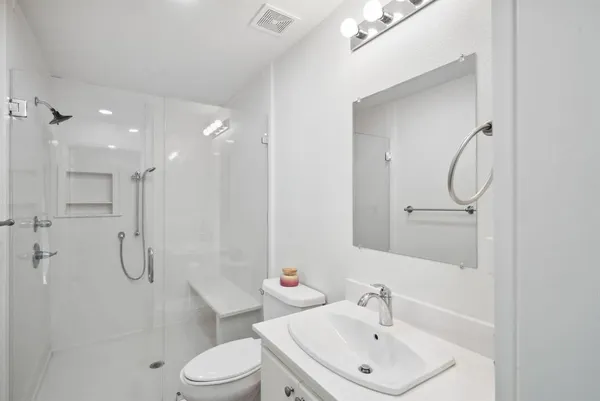 a bathroom with a toilet sink shower and mirror