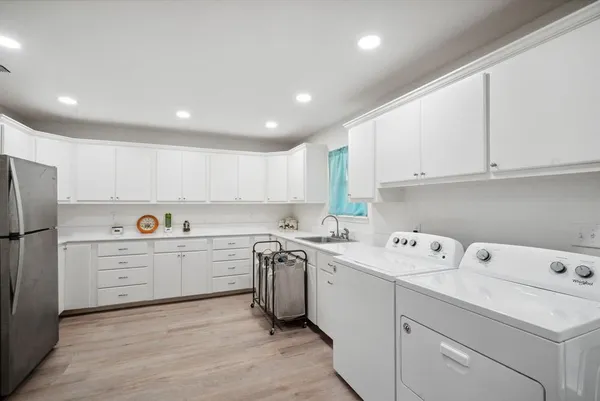a kitchen with a sink a stove a refrigerator and white cabinets