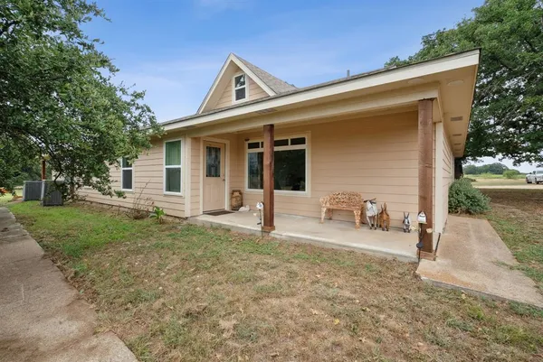 a view of a house with backyard and trees