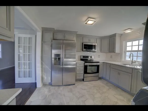 a kitchen with stainless steel appliances granite countertop a stove a sink and a refrigerator