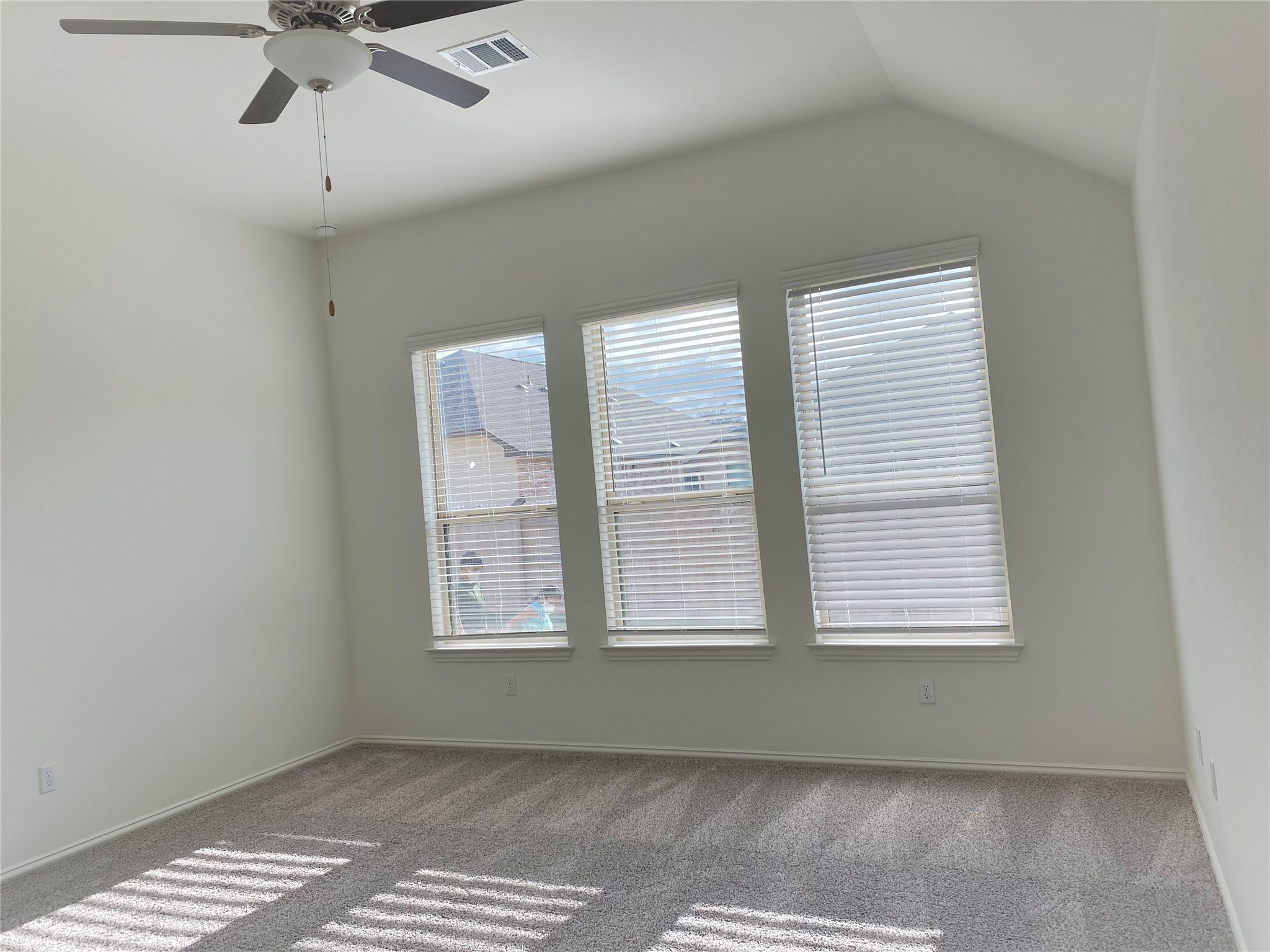 1309 Terrace View Georgetown, TX 78628 - Photo 13 of 36 Well-lit interior space with sloped ceilings and ample natural light from three large windows.