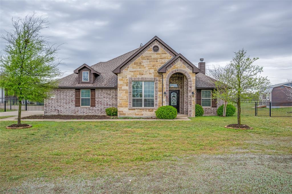 104 County Road 4223 Decatur, TX 76234 - Photo 1 of 1 French country inspired facade featuring fence, stone siding, a front lawn, brick siding, and a chimney