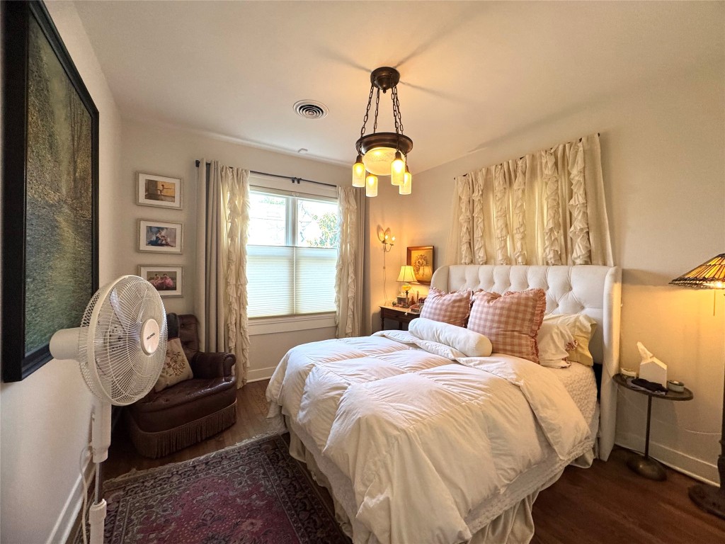 807 Leonard Street Austin, TX 78705 - Photo 15 of 32 a bedroom with a bed and a chandelier