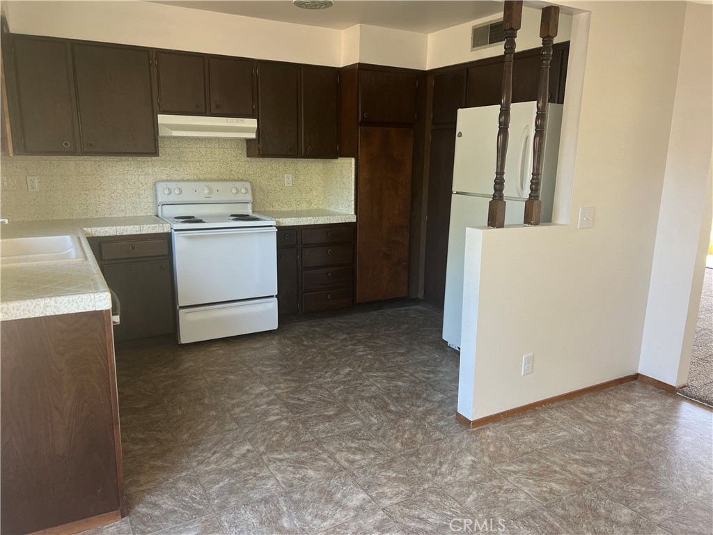 8 San Gabriel Drive, Unit B Chico, CA 95973 - Photo 2 of 7 a kitchen with a refrigerator and white cabinets
