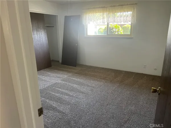 an empty room with windows and closet