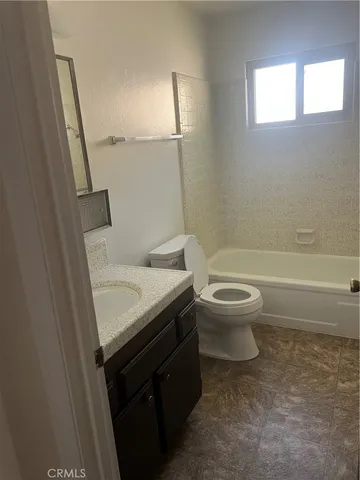 a bathroom with a granite countertop toilet a sink and a bathtub