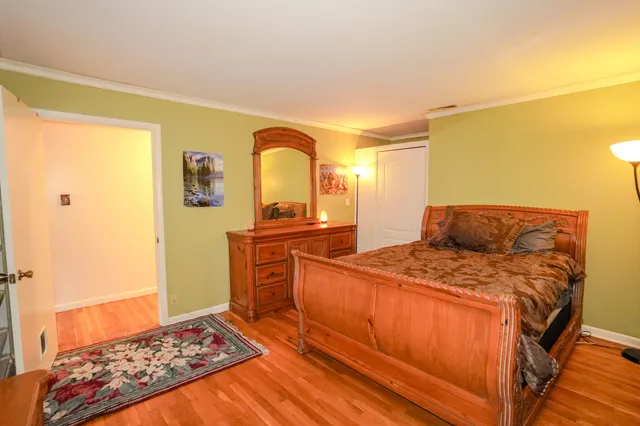 a bedroom with a bed and wooden floor