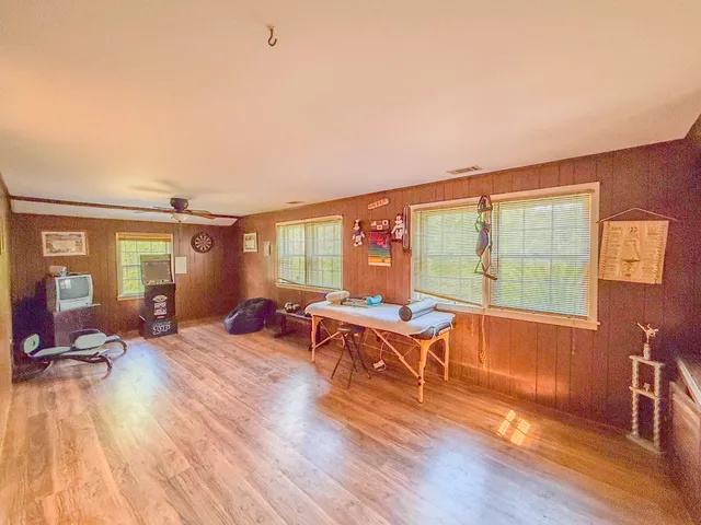 a living room with furniture a bed and wooden floor