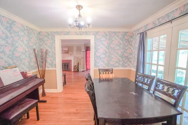 a dining room with furniture a chandelier and wooden floor