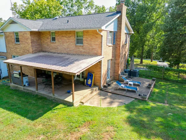 a view of a house with backyard and sitting area