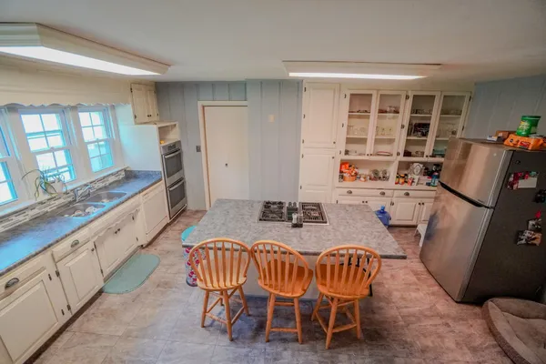a kitchen with stainless steel appliances granite countertop a stove a sink and a refrigerator