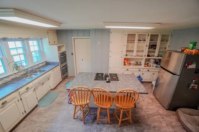 a kitchen with stainless steel appliances granite countertop a stove a sink and a refrigerator