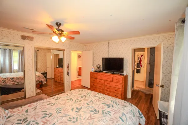 a bedroom with a large bed and wooden floor