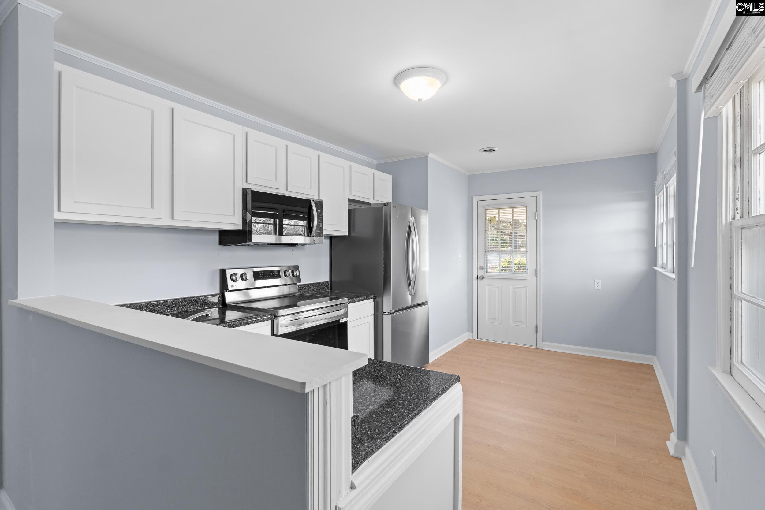 409 Wilkes Road Columbia, SC 29203 - Photo 9 of 34 a kitchen with granite countertop white cabinets and stainless steel appliances