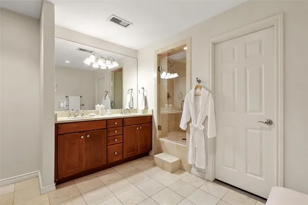 a spacious bathroom with a double vanity sink a mirror and a bathtub
