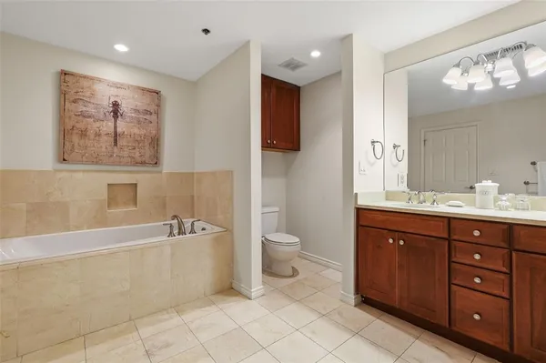 a spacious bathroom with a double vanity sink a large mirror and a bathtub