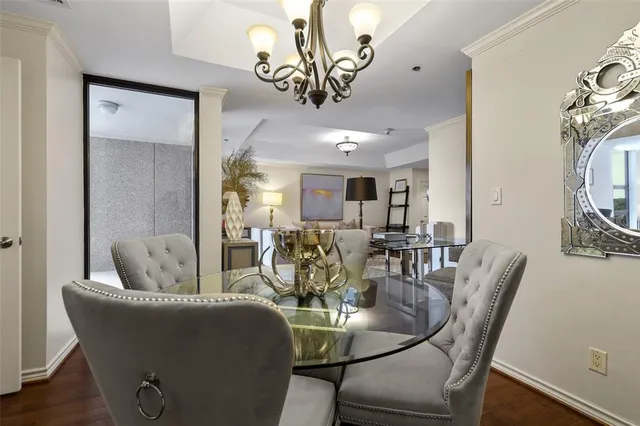 a dining room with furniture a chandelier and wooden floor