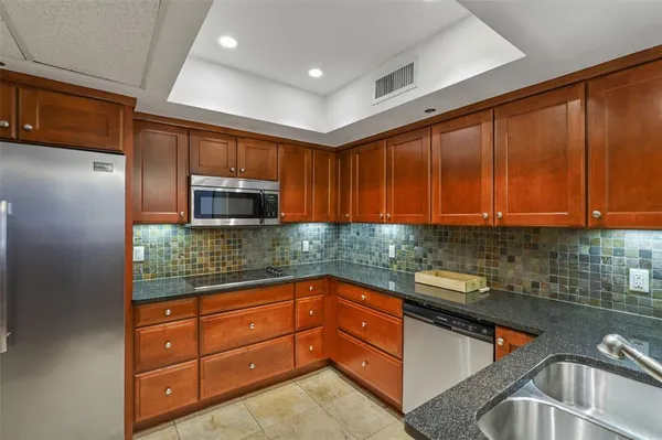 a kitchen with stainless steel appliances granite countertop wooden cabinets a sink and dishwasher