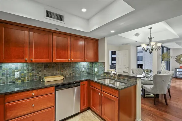 a kitchen with granite countertop a sink stainless steel appliances and cabinets