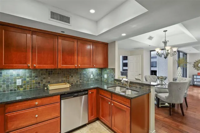 a kitchen with granite countertop a sink stainless steel appliances and cabinets