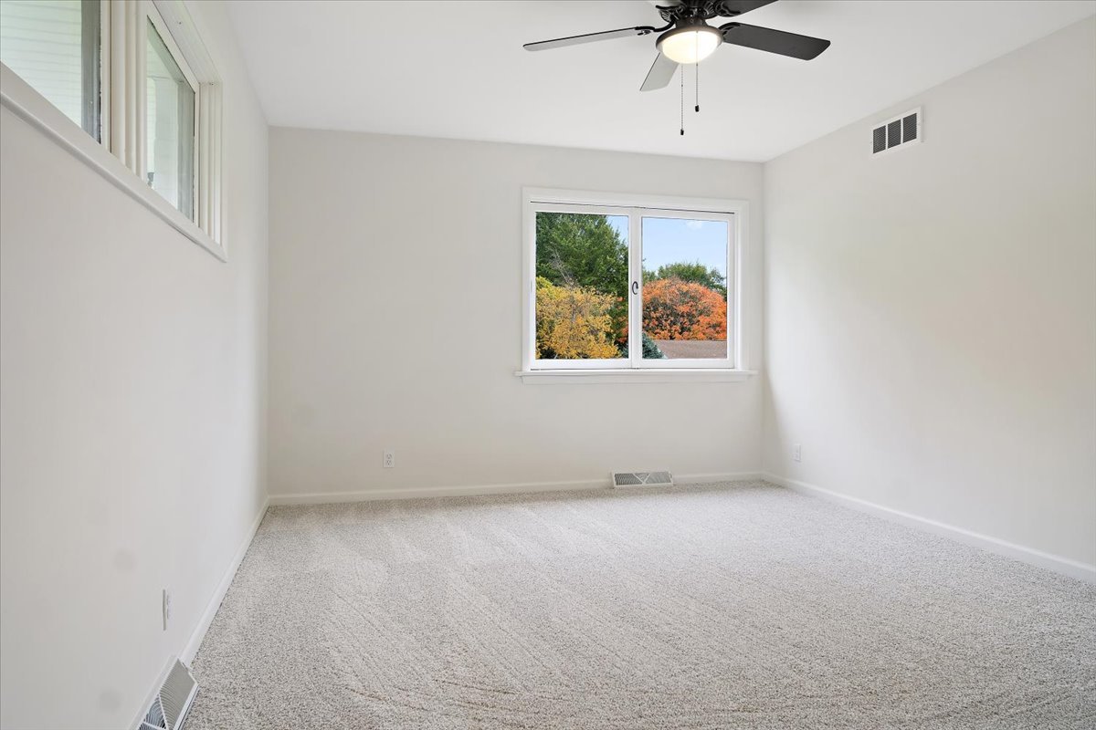 5 Ridgemont Road Normal, IL 61761 - Photo 27 of 58 an empty room with windows and chandelier fan