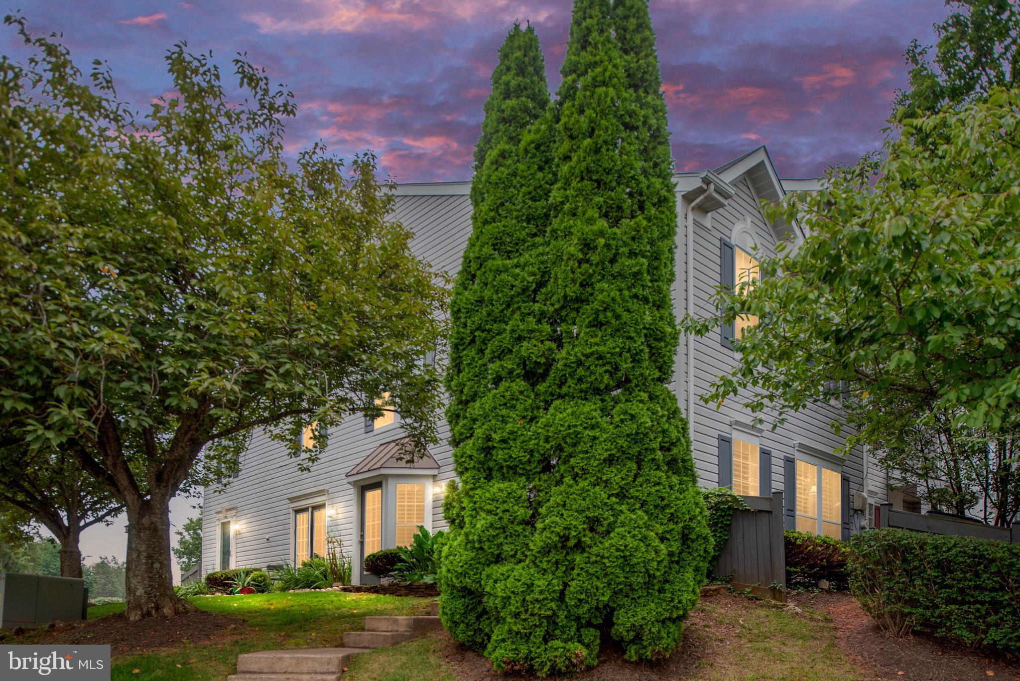 front view of a house with a yard and trees