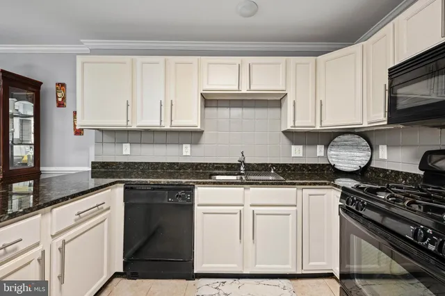 a kitchen with granite countertop a stove sink and cabinets