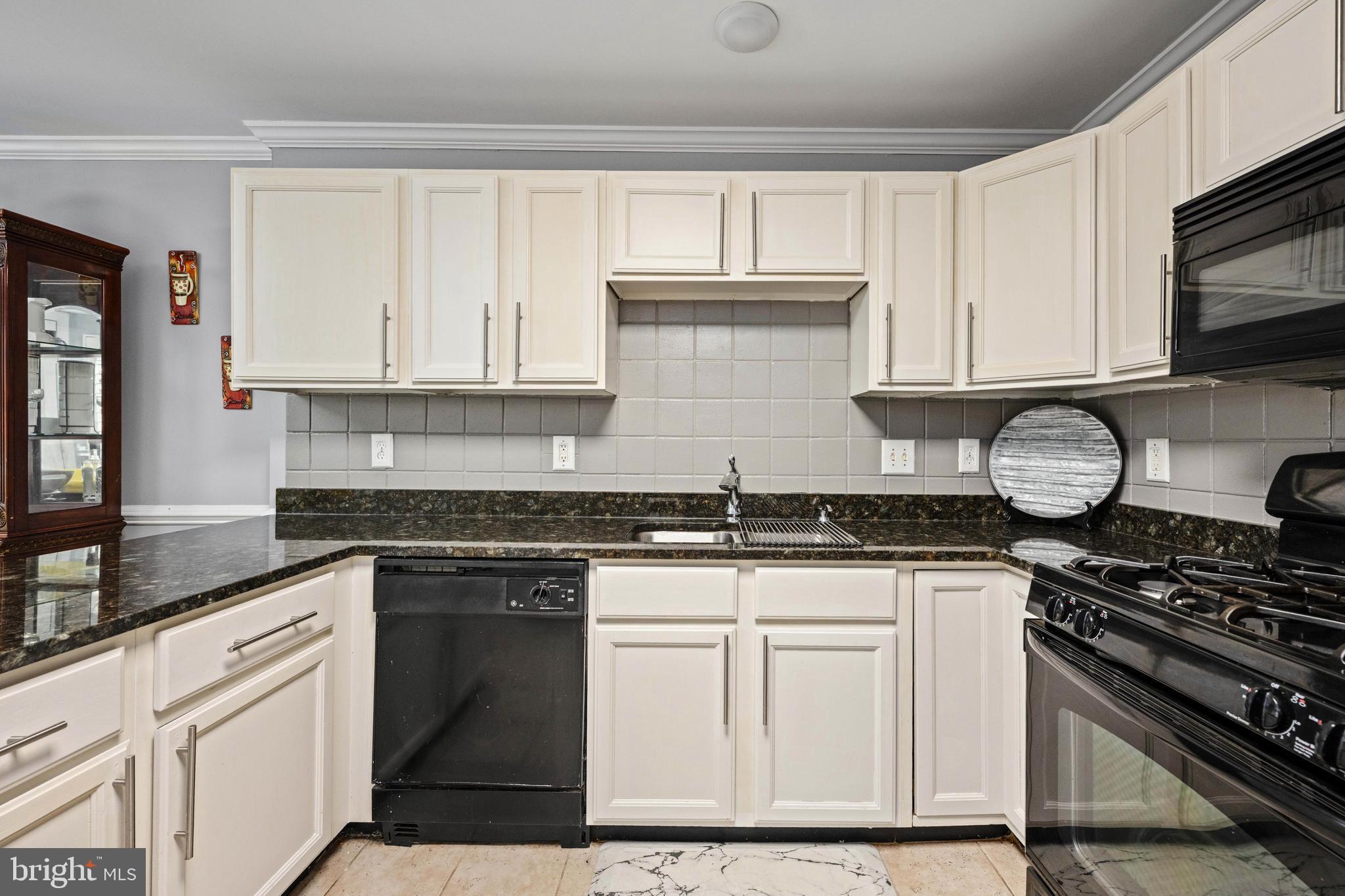 9332 Wax Myrtle Way Manassas, VA 20110 - Photo 24 of 50 a kitchen with granite countertop a stove sink and cabinets