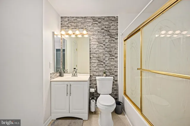 a bathroom with a toilet a sink and a large mirror