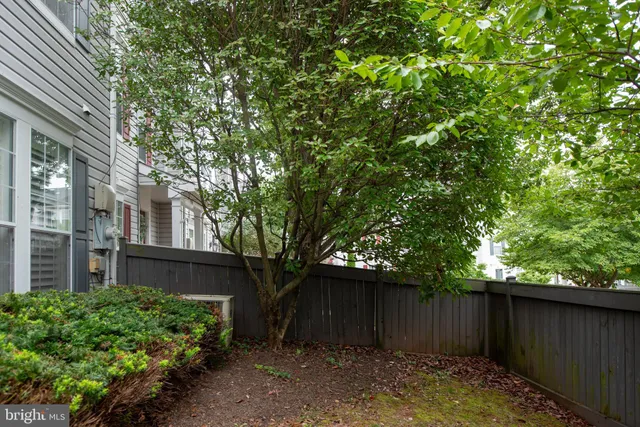 a view of a house with a large tree and wooden fence