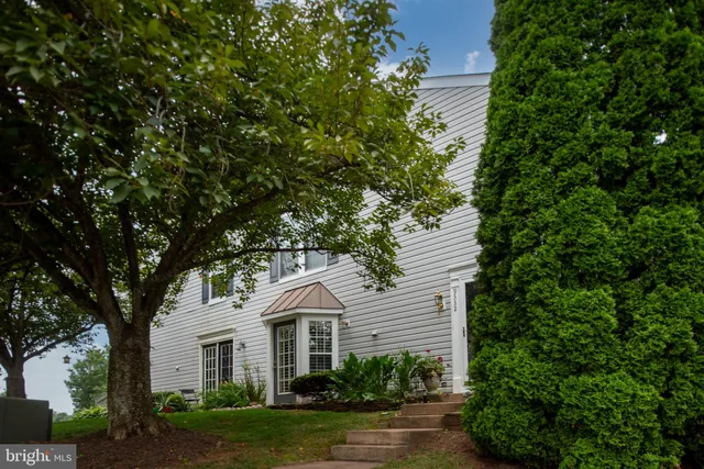 a front view of a house with a yard and green space