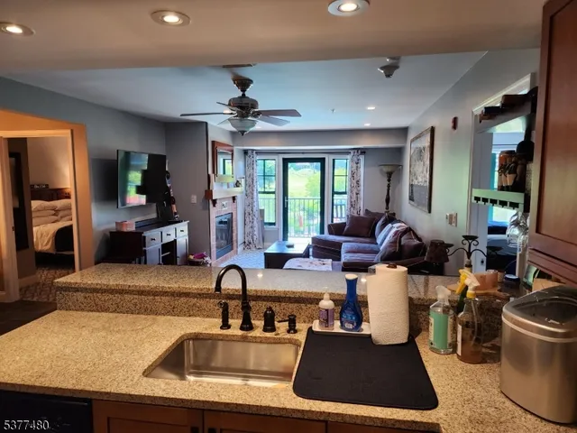 a living room with furniture a large window and flat screen tv