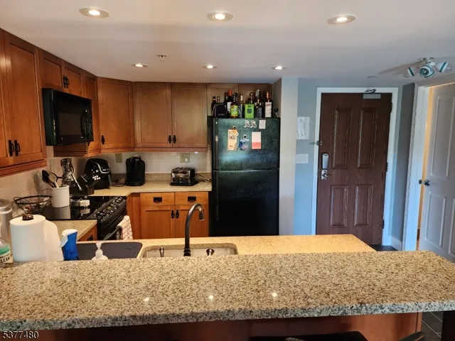 a kitchen with stainless steel appliances granite countertop a refrigerator and a sink