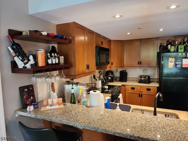 a kitchen with stainless steel appliances granite countertop a sink refrigerator and microwave
